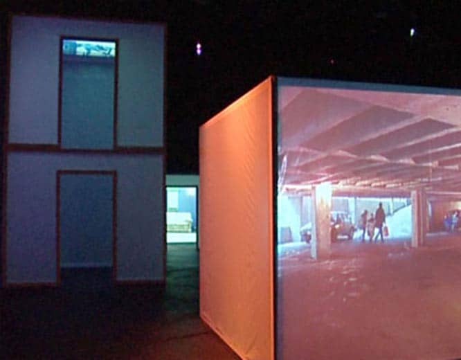 Photographs showing red cube with projection in dark space