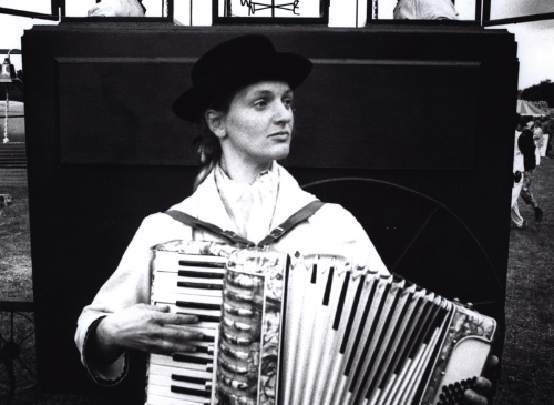 A woman is playing the acordian, the image is black and white.