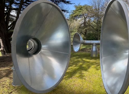 silver tubes and speakers sit in woodland