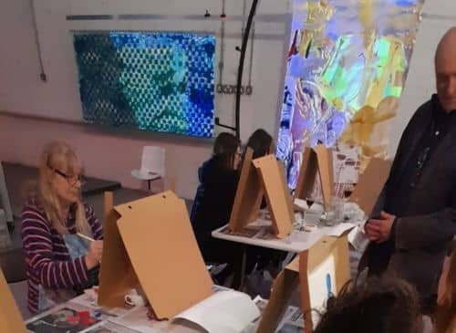 Artists painting on to cardboard boxes